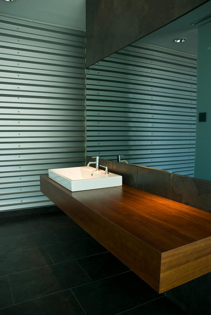 Stylish bathroom interior with wooden sink and striped walls.